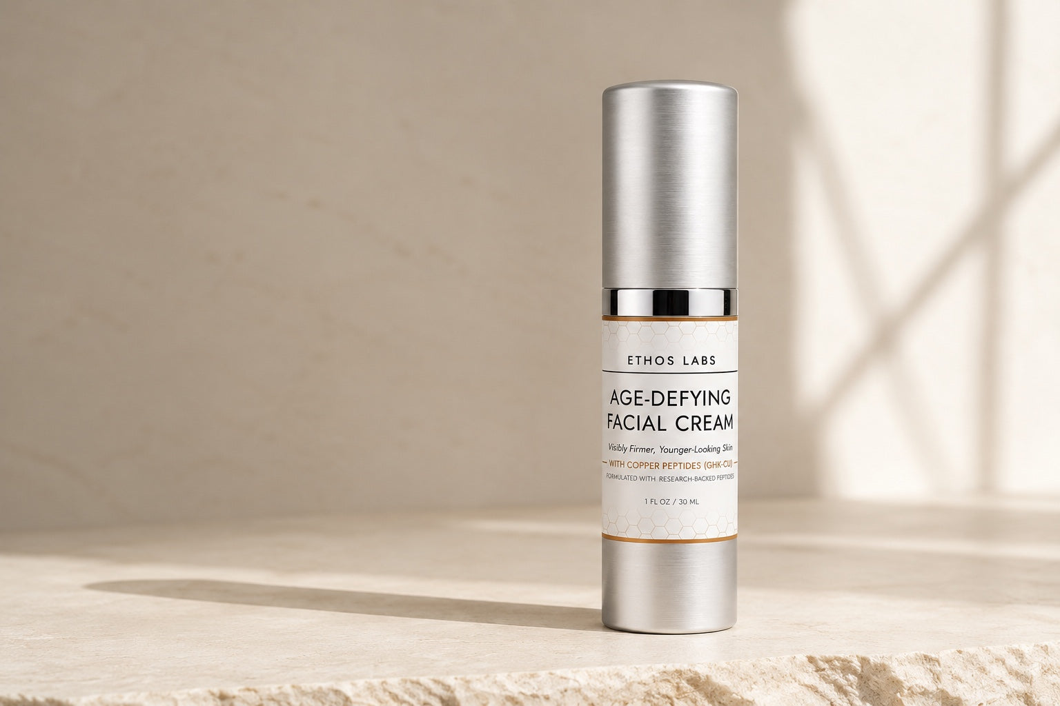 Ethos Labs Age-Defying Facial Cream silver pump bottle on a stone surface