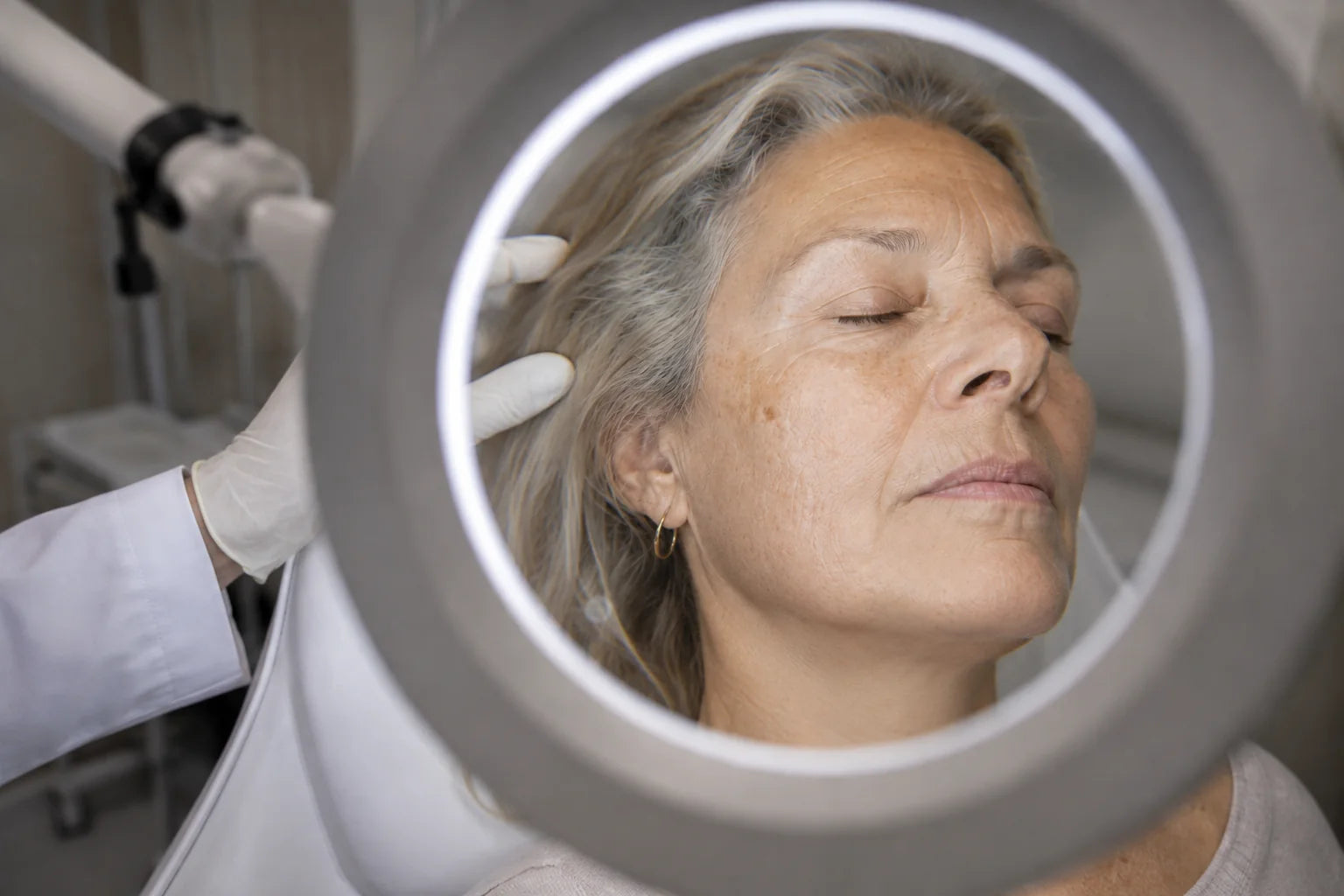 A skin assessment under a magnifying lamp in a treatment room