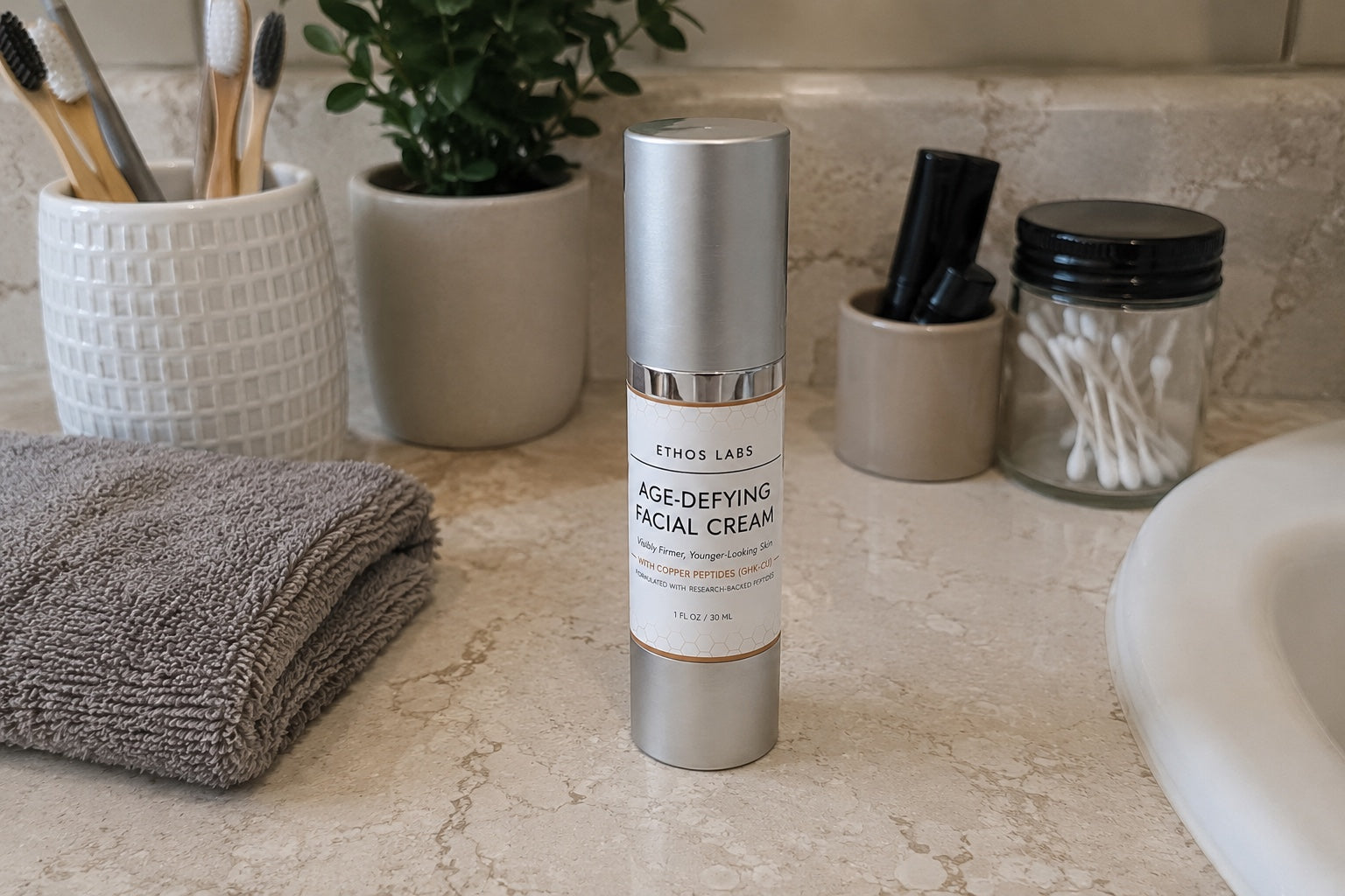 Ethos Labs Age-Defying Facial Cream pump bottle on a bathroom counter